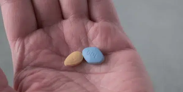 手中握有威而鋼與犀利士藥丸，呈現兩種壯陽藥的差別